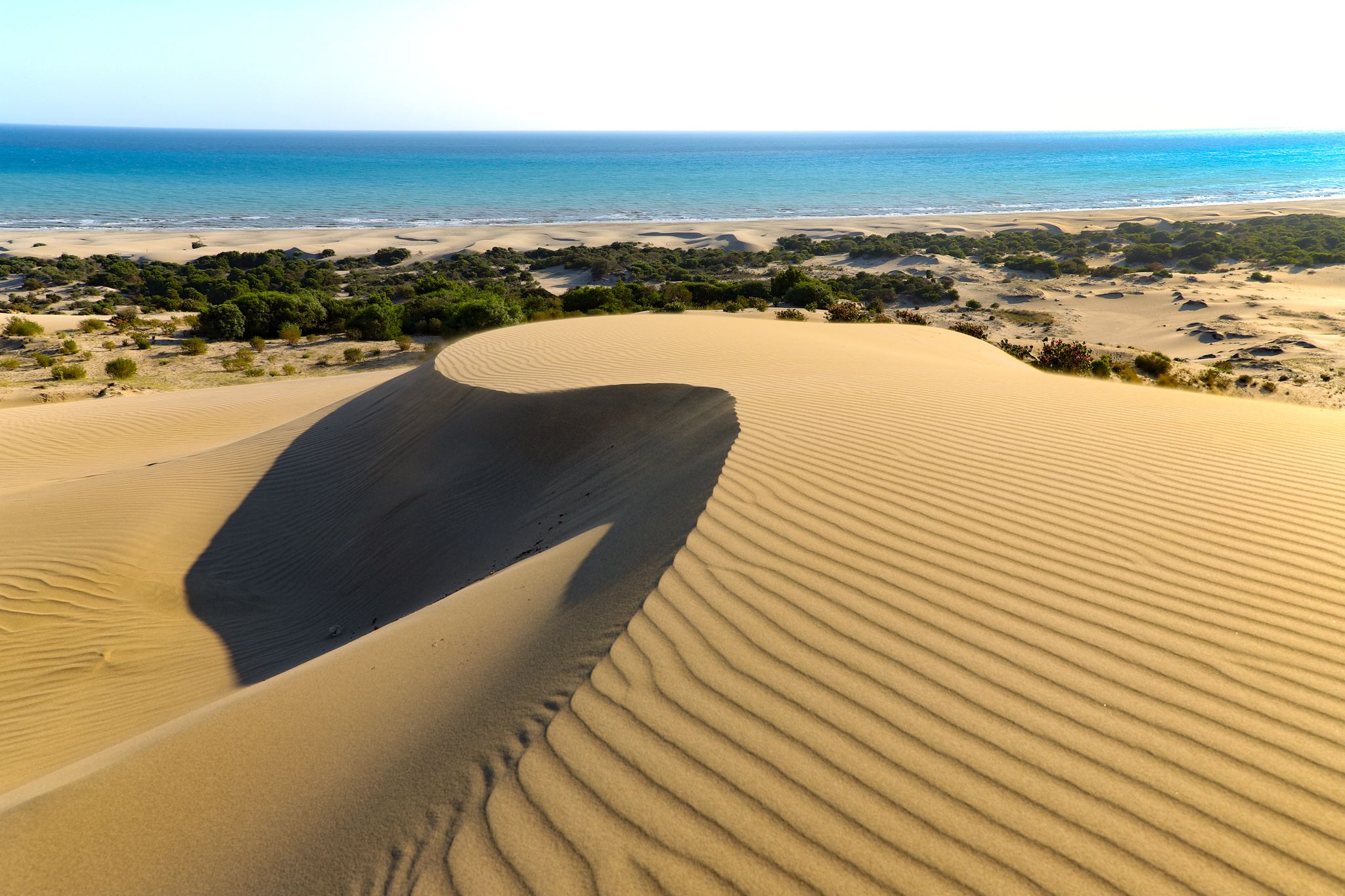 photo of Patara beach is a famous tourist landmark and natural destination in Turkey. Majestic view of orange sand dunes and hills glows in the rays of the warm sunset.