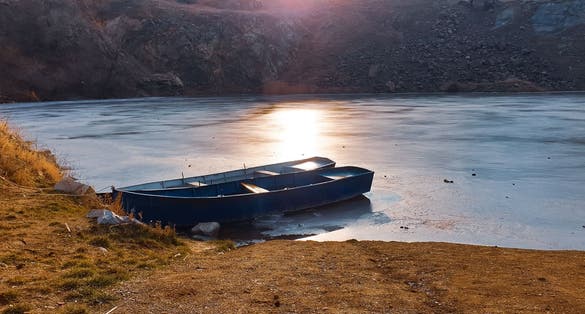 photo of view of Frozen lake with boats in Tulcea, Romania.