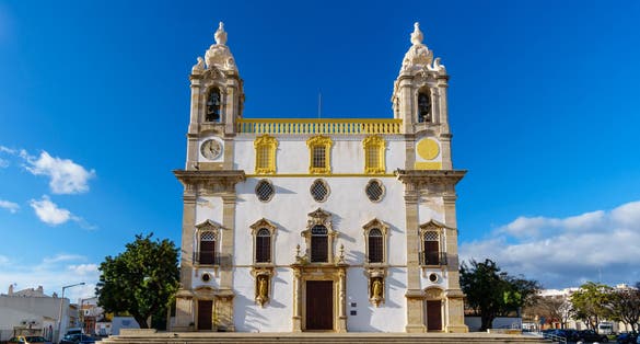 Carmo Church (Igreja do Carmo ) in Faro, Portugal with its famous chapel of bones in warm sunlight - frontal perspective, landscape orientation.