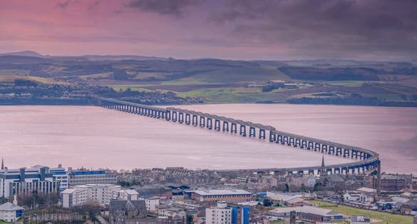 photo of view of From the monument at Dundee law Hill looking down over the city to the Fourth or Tay Railway Bridge Dundee Scotland at sunset.
