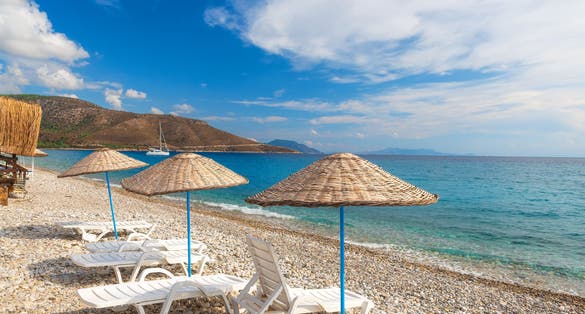 Photo of sun loungers and umbrellas on Palamutbuku beach in Datca Peninsula, Mugla region, Turkey.