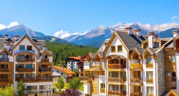Photo of Bansko, Bulgaria summer view with houses and Pirin peaks panorama.