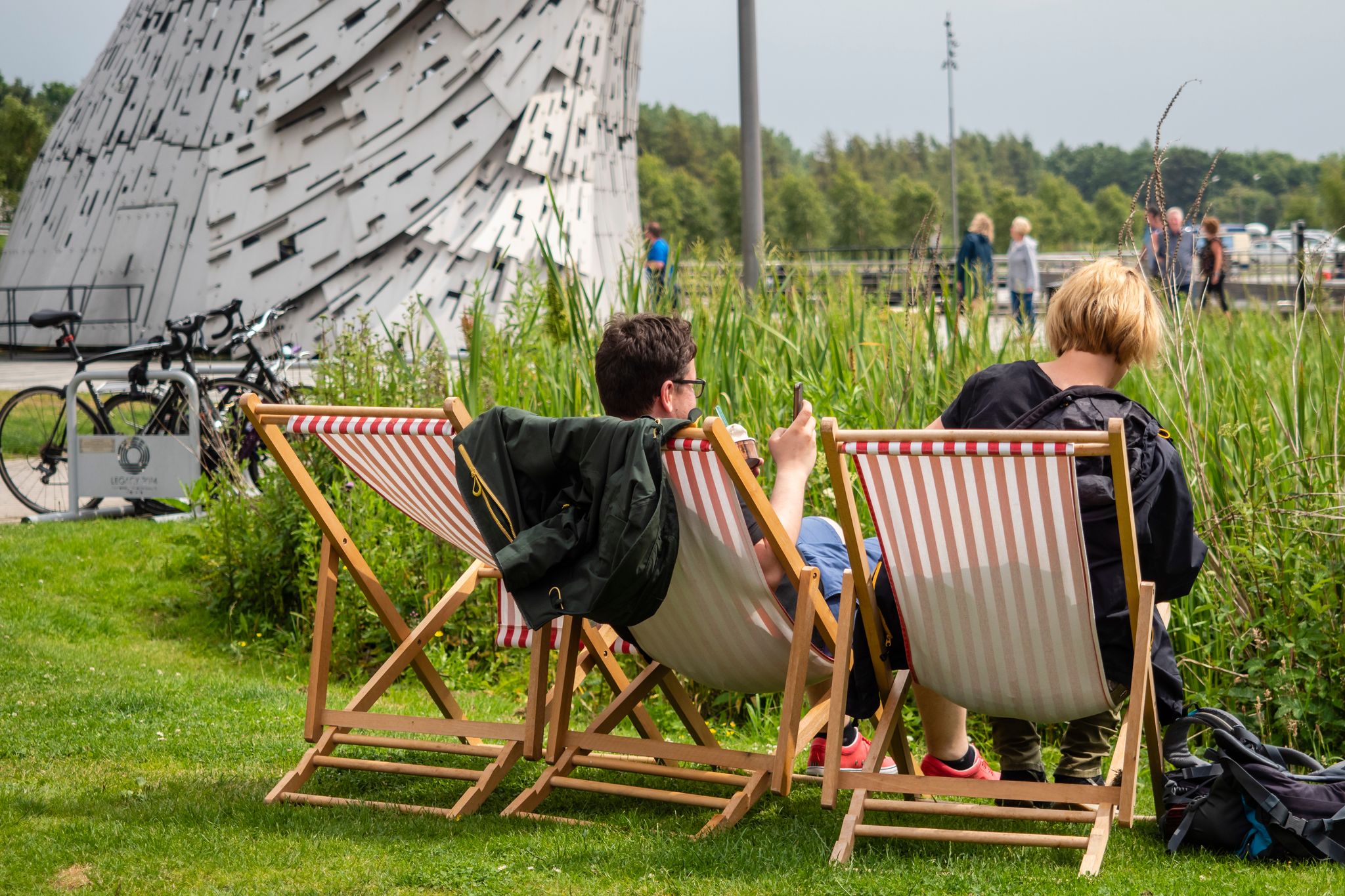 Falkirk, Scotland, UK Couple enjoy refreshments SITTING IN DECK CHAIRS AT THE kelpies IN Scotland
