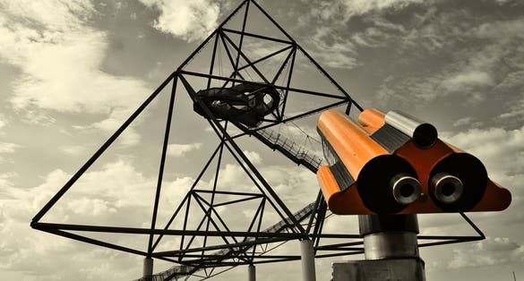 photo of view of the Tetraeder in Bottrop behind a paid binoculars.