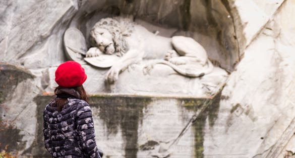 Photo of girl looking at the Lion Monument Lucerne  in Switzerland.