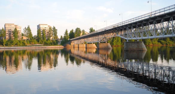photo of view of The park bridge, "Parkbron", in Skellefteå city center during summer. The south part of the city is reflecting the in river, called Skellefteälven