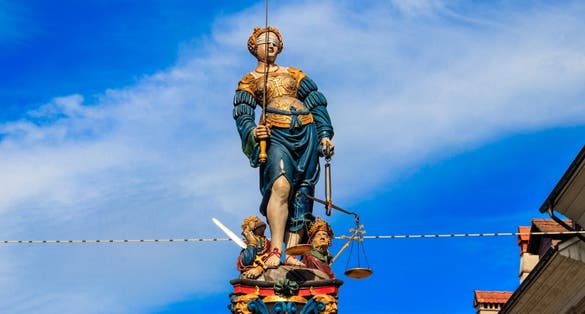 photo of Fountain of Justice (Gerechtigkeitsbrunnen) is a 16th-century fountain with blue sky background in the Old City of Bern, Switzerland.