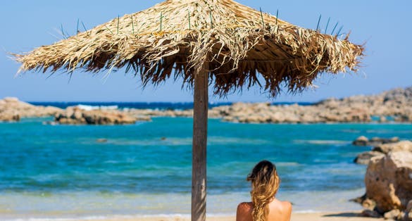 the girl under the umbrella looks at the sea.