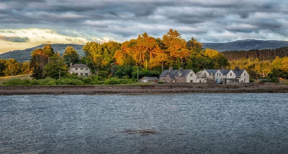 Photo of Kenmare Bay with residential houses in the distant background at Kenmare, County Kerry, Ireland.