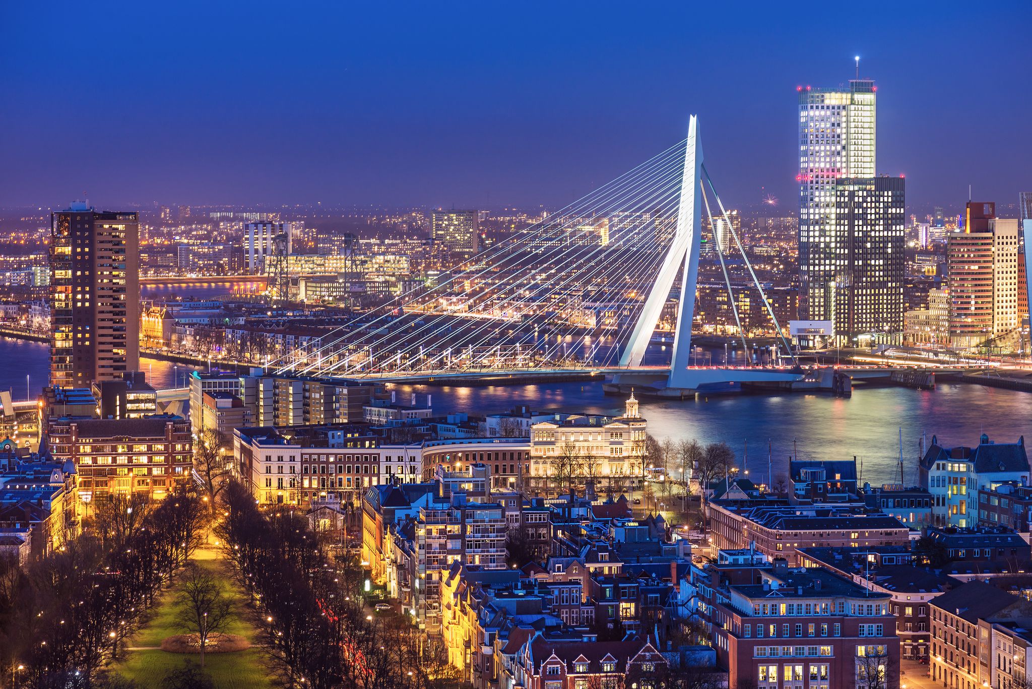 Photo of Rotterdam skyline with Erasmus bridge at twilight as seen from the Euromast tower, The Netherlands.