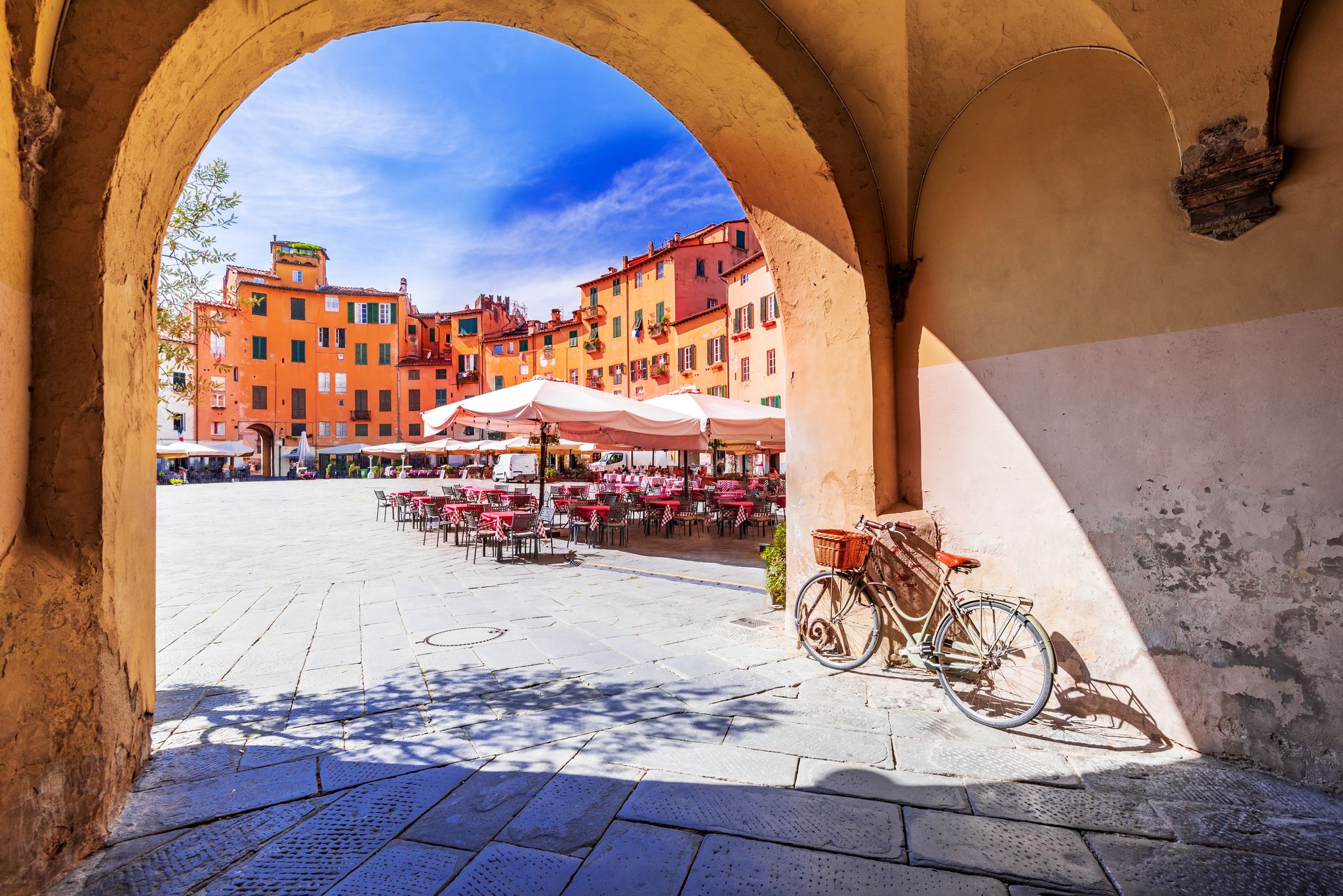 photo of view of Lucca, Italy - View of Piazza dell'Anfiteatro square through the arch, ancient Roman Empire amphitheater, famous Tuscany.