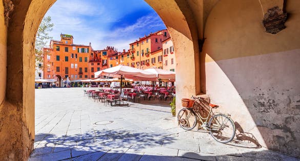 photo of view of Lucca, Italy - View of Piazza dell'Anfiteatro square through the arch, ancient Roman Empire amphitheater, famous Tuscany.