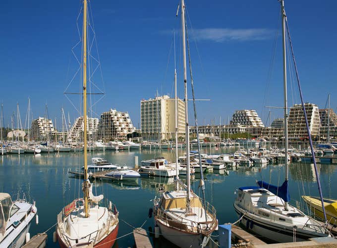 Boats in the harbour and modern buildings in the background, at la grande motte, languedoc, languedoc roussillon, france, europe