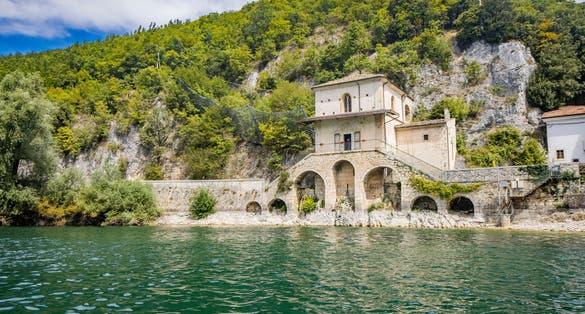 The enchanting Lake Scanno, in Abruzzo, in the province of L'Aquila, located between the Marsican Mountains. The small Church of Santa Maria dell'Annunziata overlooks the waters of the lake.