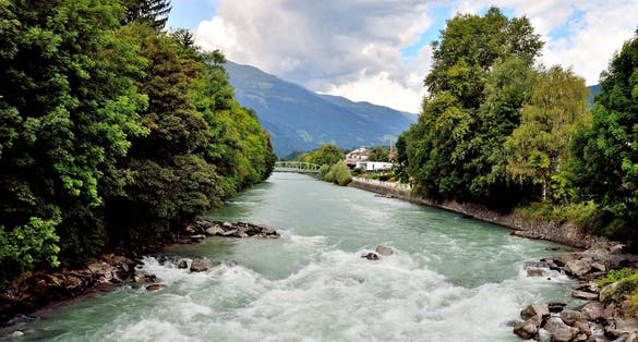 PHOTO OF VIEW OF Swirling river and trees in Lienz, Austria.
