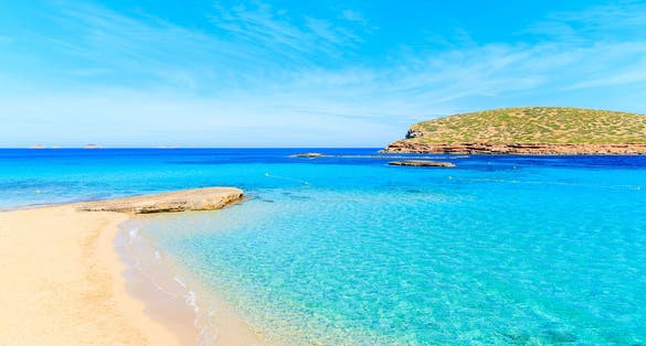 Photo of beautiful sandy Cala Comte beach with azure blue sea water, Ibiza island, Spain.