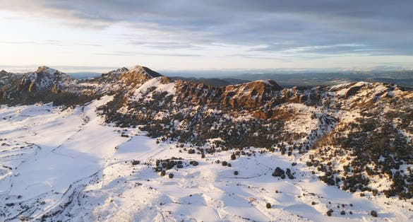 photo of view of Aerial view of snow covered mountains at sunset in Obarenes mountain range, Burgos province, Spain.