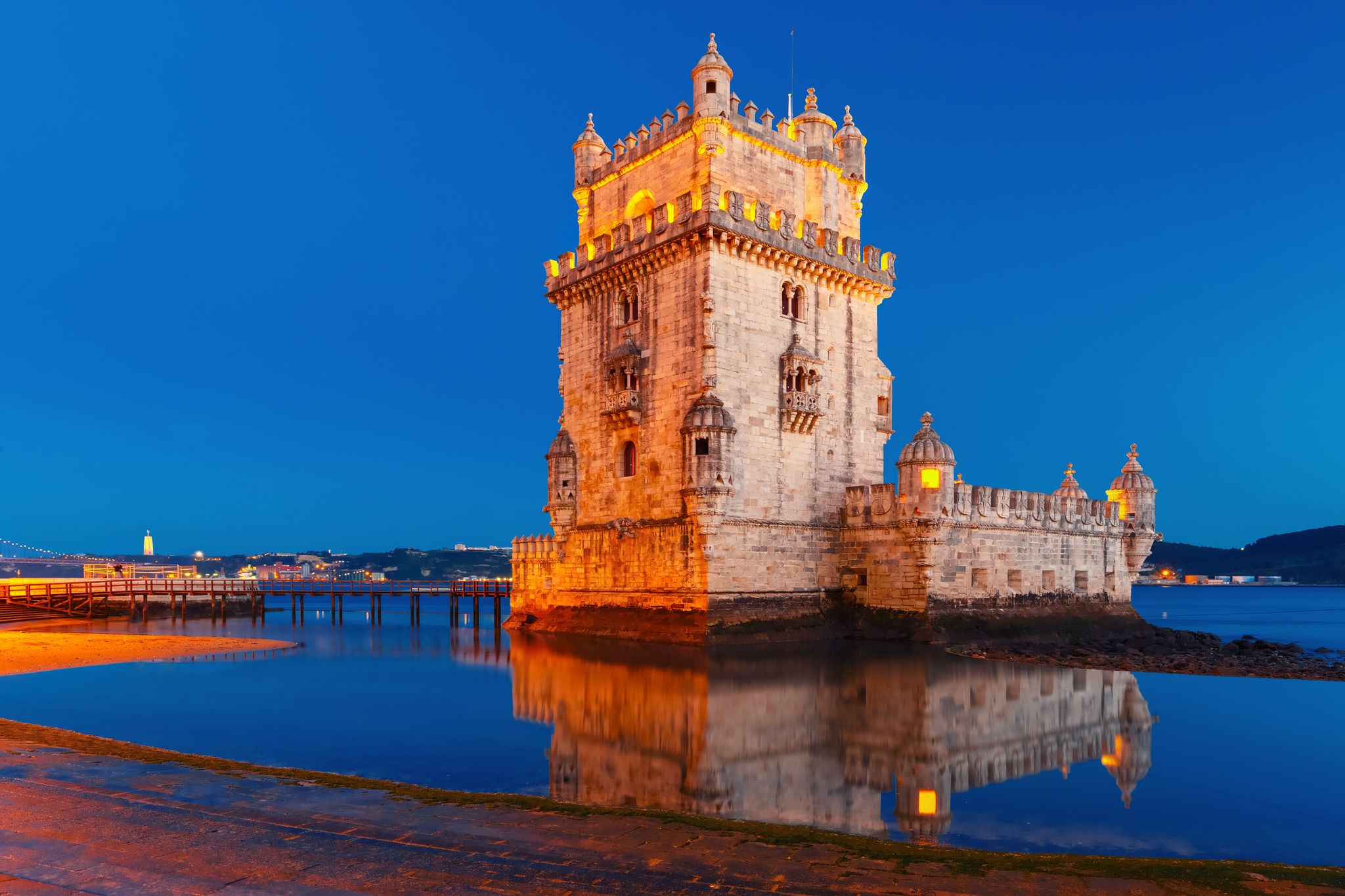 Photo of Belem Tower or Tower of St Vincent on the bank of the Tagus River during evening blue hour, Lisbon, Portugal.