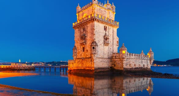 Photo of Belem Tower or Tower of St Vincent on the bank of the Tagus River during evening blue hour, Lisbon, Portugal.