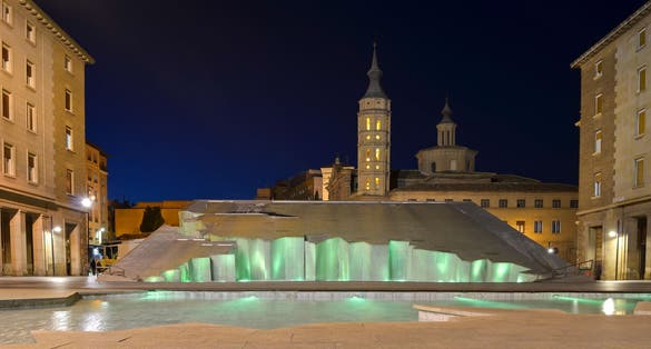 Photo of Zaragoza fountain (Fuente de la Hispanidad) lit up at night in Plaza del Pilar, Spain.