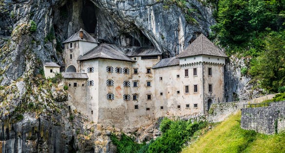 Dramatic scenery of medieval cliff top Predjama castle and caves, Slovenia