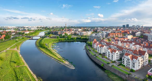 Photo of aerial view of Warta river and residential buildings in the district of old Port, Poznan, Poland.