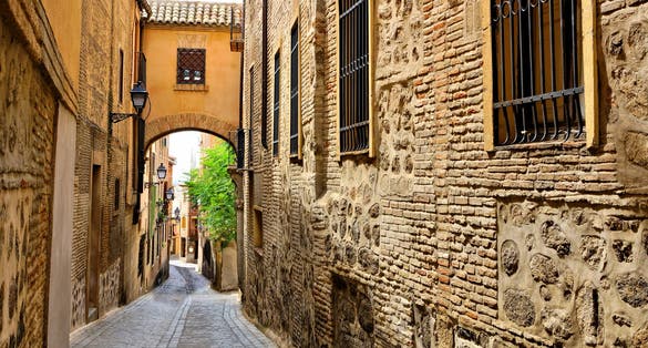photo of view of  Historic street with archway in the Old Town of Toledo, Spain