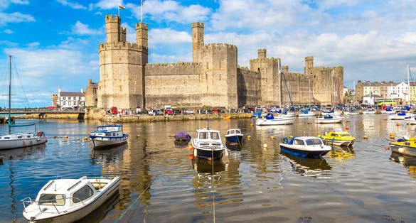 Photo of beautiful view of Caernarfon Castle in Wales in a beautiful summer day.