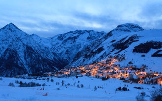 Photo of aerial view of beautiful winter landscape of Les Deux Alpes surrounded by mountains, France.