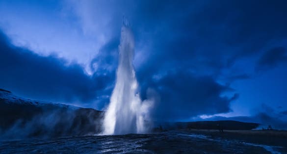 photo of the great geysir at night in Iceland.