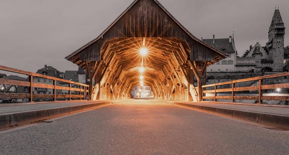 photo of entrance of covered wooden bridge over the river Reuss in Bremgarten, Switzerland.