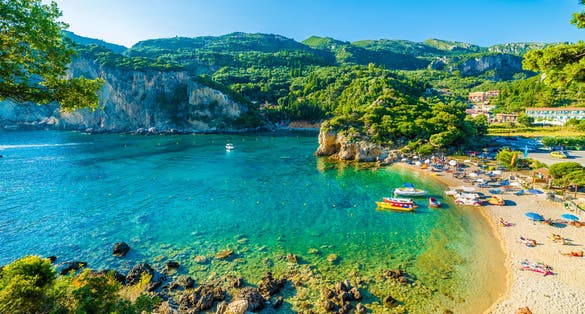 Photo of beautiful beach and boat in Paleokastritsa, Corfu island, Greece.