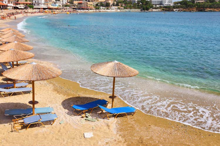 Photo of the beautiful beach with sunbeds and umbrellas of Agia Pelagia near Heraklion, Crete, Greece.