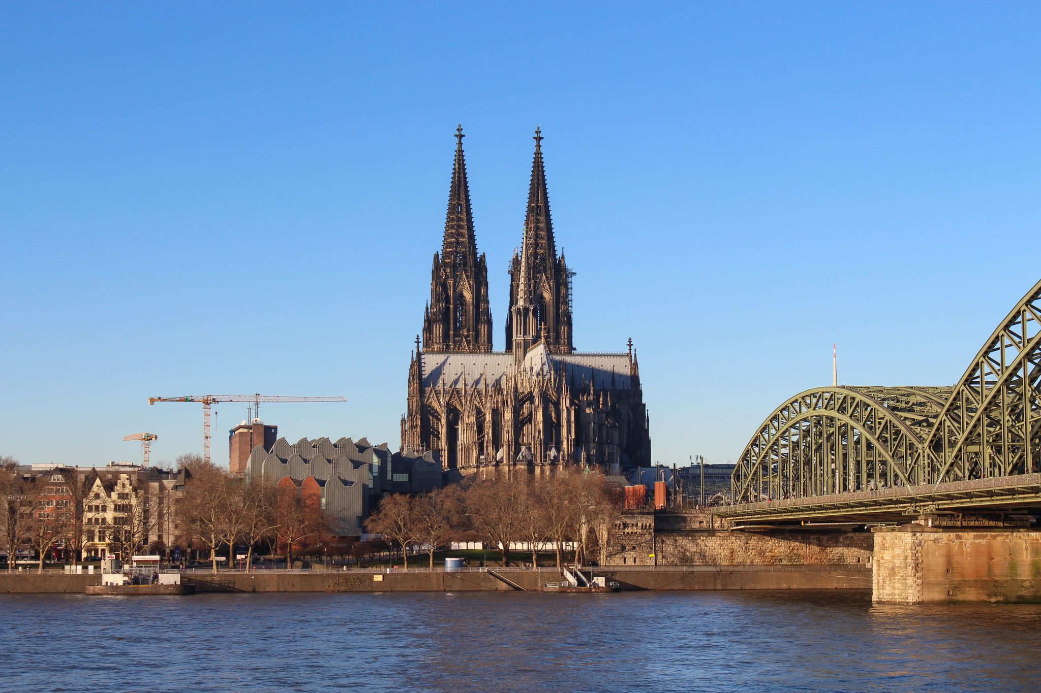 photo of view of The Hohenzollern bridge over Rhine river on a sunny day. The Cologne Cathedral (Kolner Dom) in the city of Cologne, Germany. It is the largest Gothic church in northern Europe.,Cologne Germany.