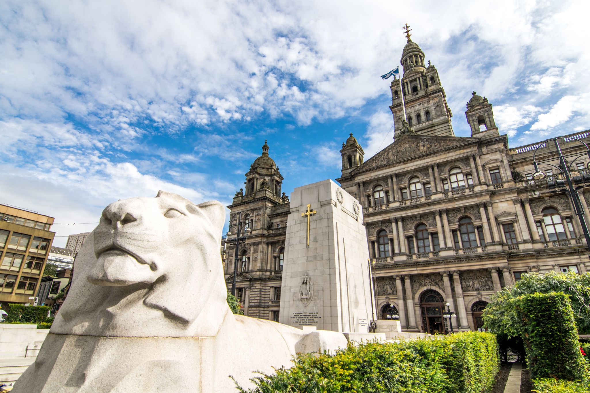 The white lion statue in front of the Cenotaph with the Glasgow City Chambers as a background.