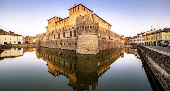 Medieval Fontanellato castle with tower and reflection on water during sunset, Parma, Emilia Romagna, Italy