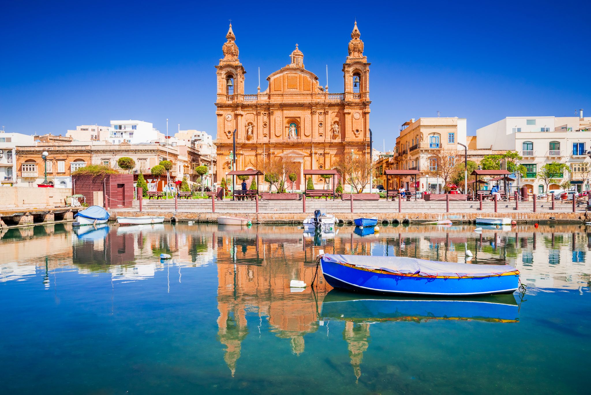 Photo of Msida Marina boat and church reflection into water, Malta.
