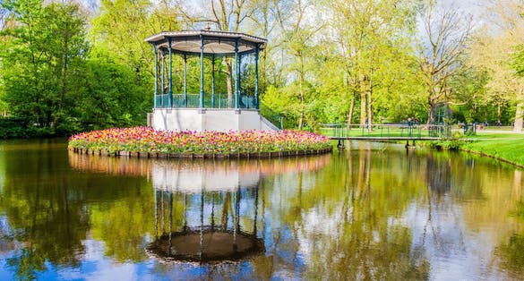 Photo of pond and beautiful blooming tulips in Vondelpark, Amsterdam.