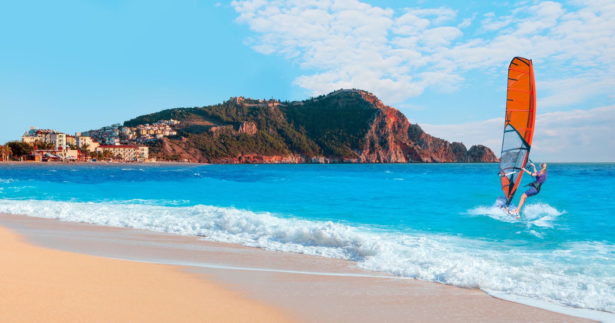 photo of beautiful blue sky with windsurfer surfing the wind on waves at cleopatra beach - Alanya, Turkey.