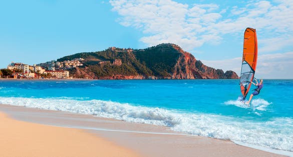 photo of beautiful blue sky with windsurfer surfing the wind on waves at cleopatra beach - Alanya, Turkey.