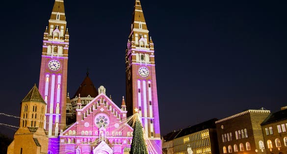 photo of view The Votive Church and Cathedral of Our Lady of Hungary in the evening on World Prematurity Day 2022 Szeged, Hungary.