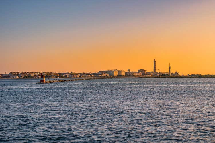 Breakwater of Aveiro estuary with buildings and Barra lighthouse in the horizon at golden hour, Gafanha da Nazaré PORTUGAL