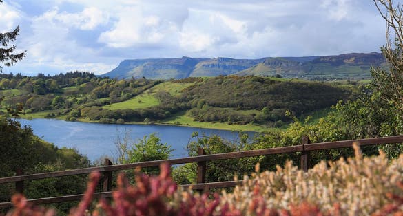 photo of view of Landscape in rural County Sligo, Ireland on spring day featuring Benbulben Mountain and nearby hills viewed from across Lough Colgagh