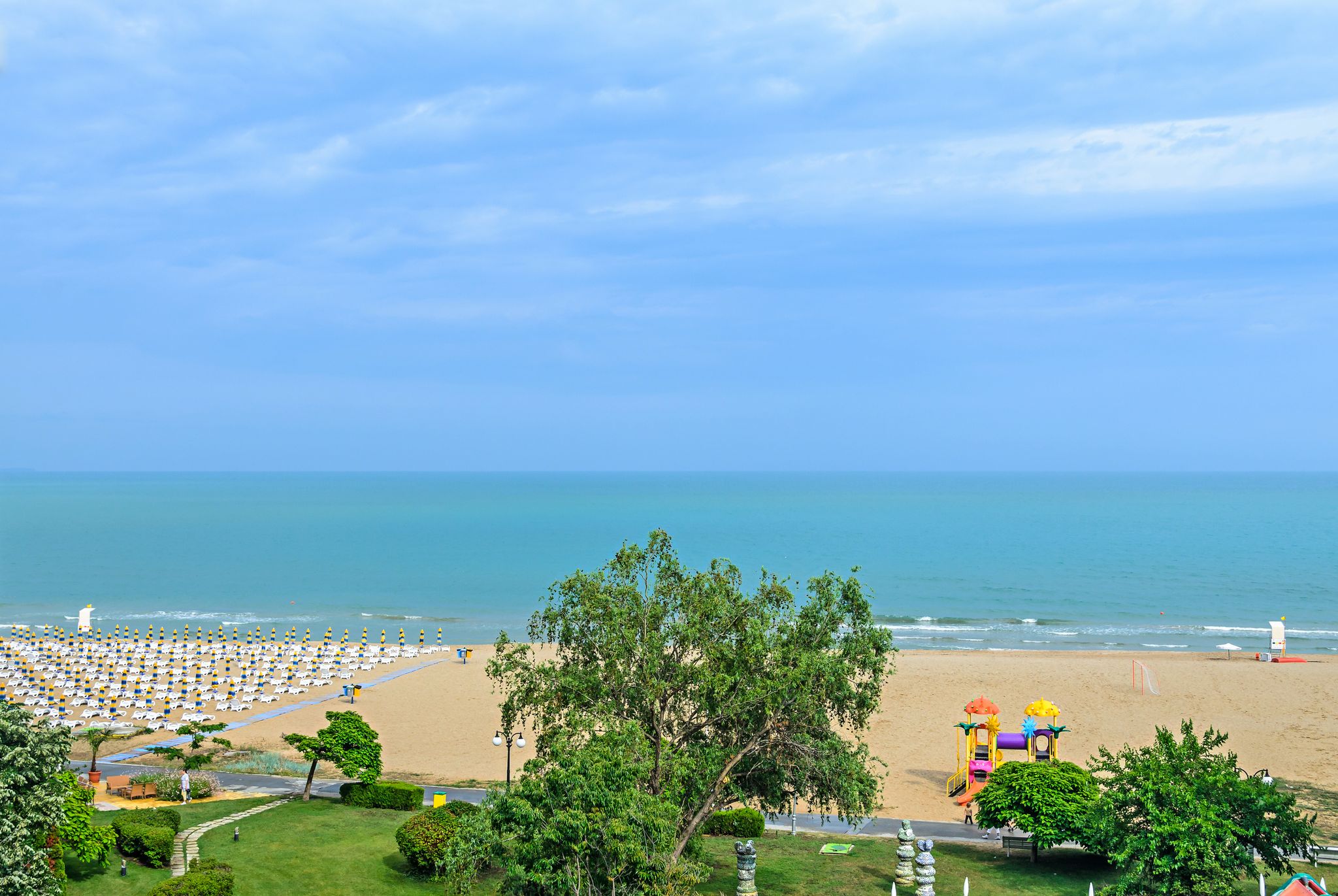 photo of view of Beach of Black Sea from Albena, Bulgaria with golden sands, blue clear water, green trees.,Obrochishte Bulgaria.
