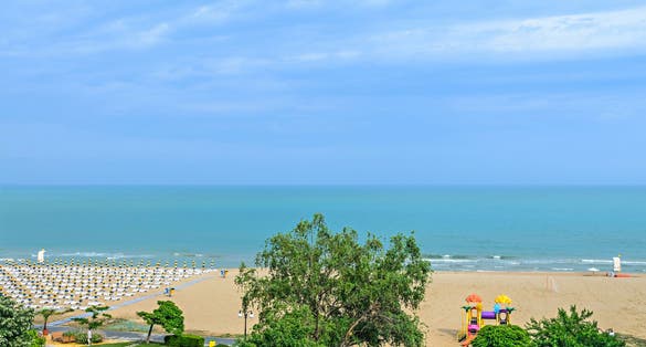 photo of view of Beach of Black Sea from Albena, Bulgaria with golden sands, blue clear water, green trees.,Obrochishte Bulgaria.