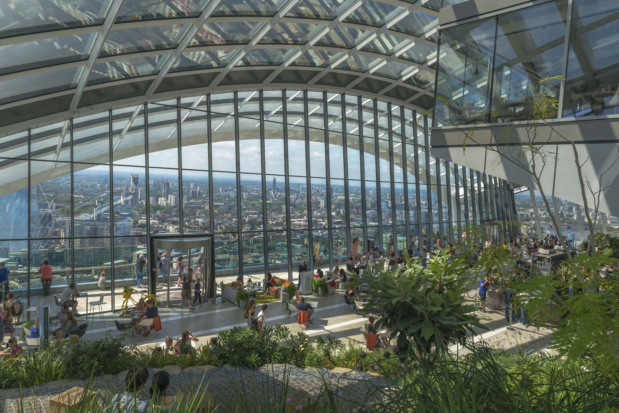 Visitors relaxing in Sky Garden London with panoramic skyline views through floor-to-ceiling glass windows..jpg