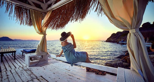 Photo of tourist relaxing by the sea and sunset enjoying perfect beach holiday vacation in Bodrum.