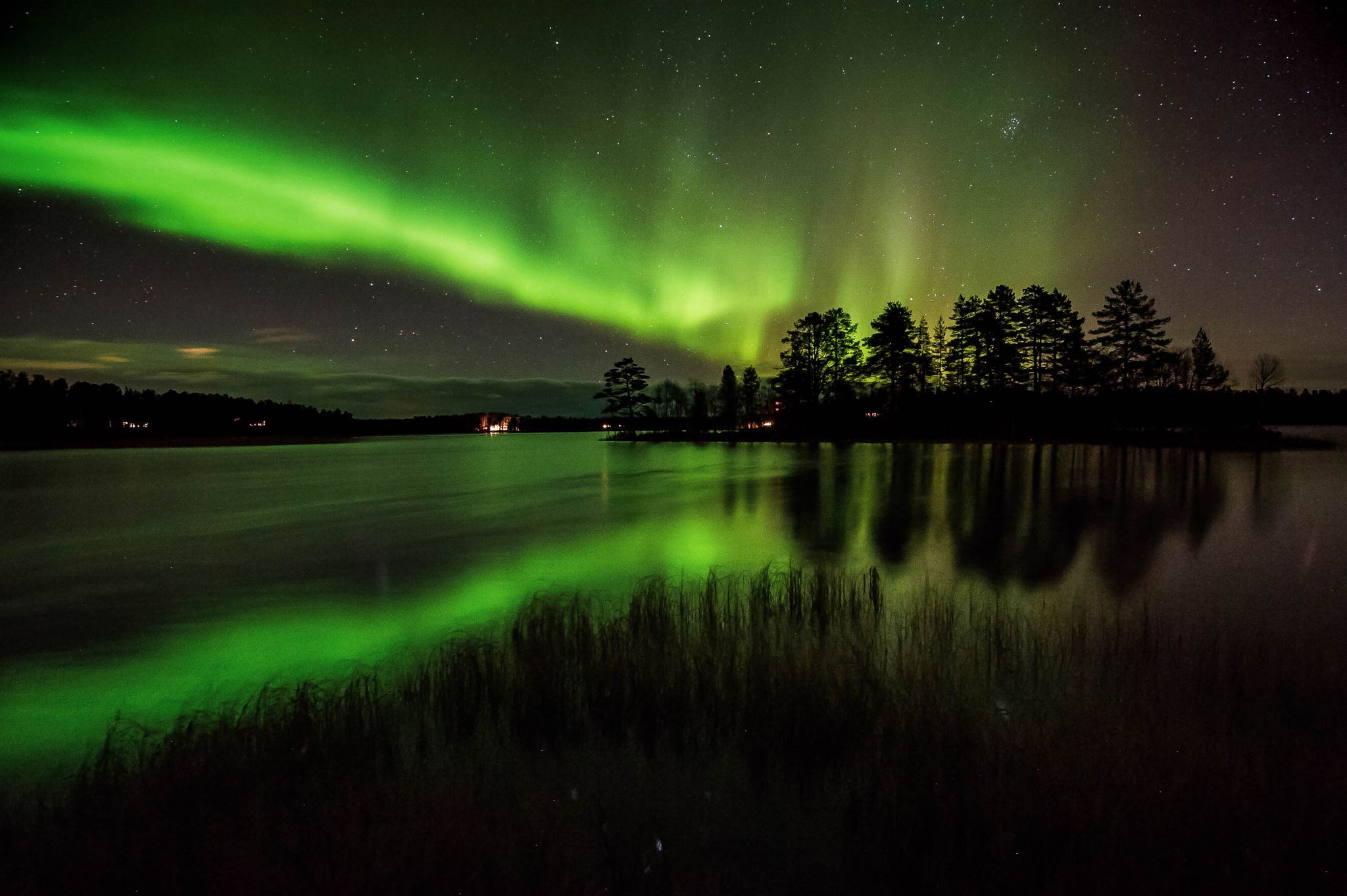 Photo of northern lights and it's reflection in the lake in Kuusamo, Finland.