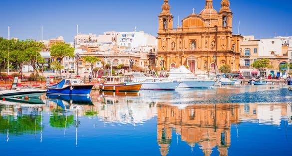 Photo of Marina boat and church reflection into water, Valletta, Malta.