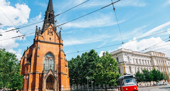 Photo of old town street, The Church of Jan Amos Comenius Red Church and tram in Brno.